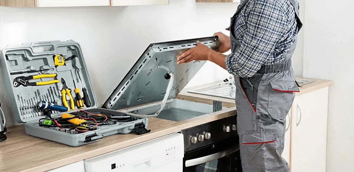 Handyman repairing a cooktop and checking wiring connections in Overland Park, KS