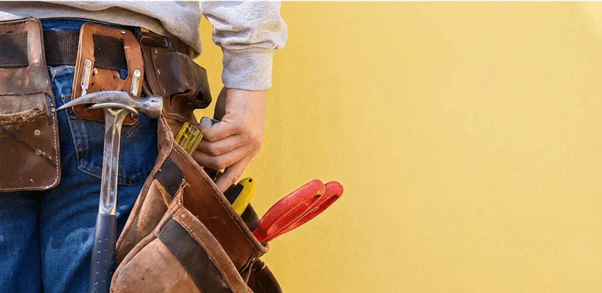 Handyman with tool belt ready for home repairs and maintenance in Overland Park, KS