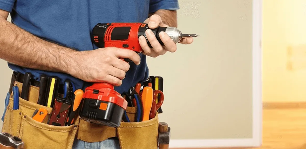 Handyman holding a power drill for home repairs and installations in Overland Park, KS